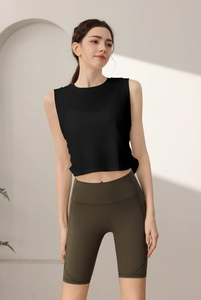 Dettaglio del crop top nero senza maniche e pantaloncini da yoga a vita alta oliva