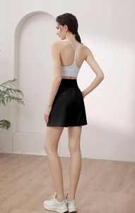 Detail view of white crisscross back sports bra and high-waisted black athletic shorts