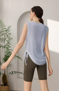 Detail of light blue yoga tank top with side drawstring design and olive green shorts