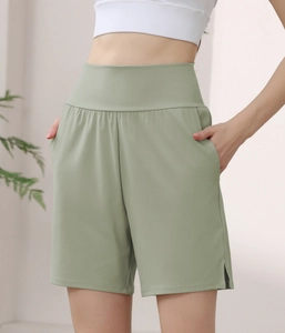 Detail of high-waisted sage green sports shorts with wide waistband and side pockets