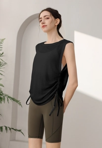 Close-up of black sleeveless sports tank top with side drawstring and olive green bike shorts