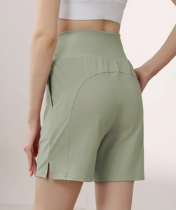 Close-up of sage green high-waisted shorts featuring a back curved seam and side split detail