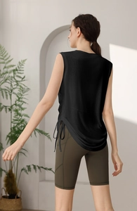 Detail of back drawstring on black yoga vest paired with olive green fitness shorts