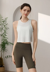 Détail du débardeur de sport blanc avec mesh et short de yoga olive à taille haute