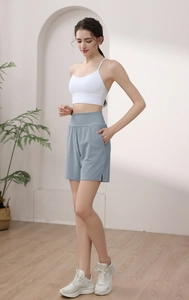 Detail of high-waisted light blue nylon sports shorts with side slits and hidden pockets