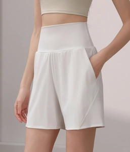 Detail of high waisted white sports shorts featuring side pockets and quick-dry fabric