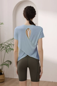 Detail of cross-back open design modal workout top with dark green biker shorts