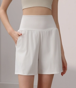 Detail of white high-waisted sports shorts with loose fit and functional side pockets