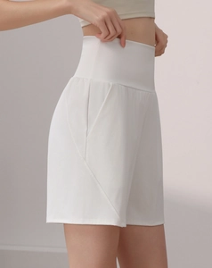 Detail view of high-waisted white sports shorts with side pockets and slimming fit