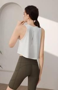 Détail du haut de sport blanc respirant avec ouverture au dos et legging vert olive