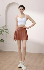 Detail showing high-waisted flared athletic skirt with petal hem and built-in liner shorts