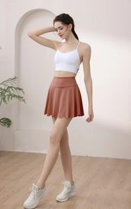 Close-up of high-waisted petal-hem yoga skirt in brick red with double-layer design