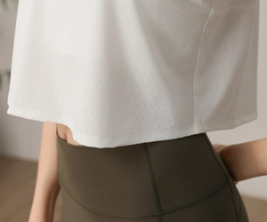 Détail du haut de yoga en mesh blanc respirant et du legging de sport taille haute olive