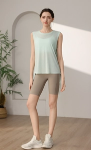 Detail of mint green double-layer yoga vest paired with high-waist charcoal biker shorts