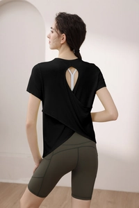 Detail of cross back cut-out yoga top with green high-waist biker shorts and side pocket