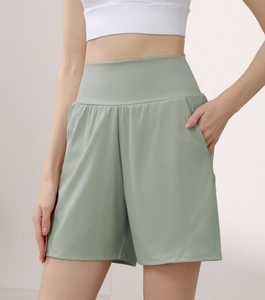 Close-up of high-waisted sage green sports shorts with wide waistband and side pockets