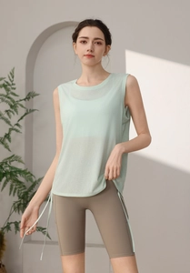 Detail of mint green sleeveless yoga top featuring side drawstring and lightweight fabric
