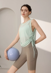 Detail of mint green side drawstring tank top paired with high waist yoga shorts