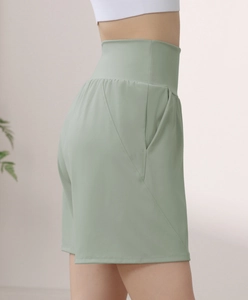 Detail view of high waisted sage green biker shorts with side pocket for fitness yoga