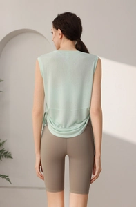 Detail view of mint green tencel sports vest with side-tie design and grey biker shorts