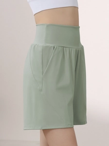 Detail view of high waisted fitness shorts in sage green with functional side pockets