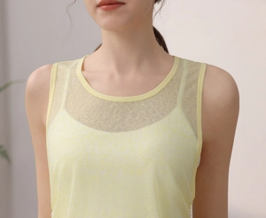 Détail du débardeur de yoga jaune clair avec empiècement en maille et finitions du col