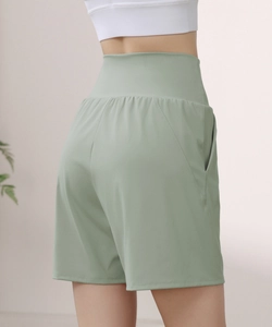Detail view of the side pocket on high-waisted bean green athletic shorts for women