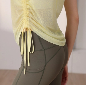Détail du haut de yoga jaune clair avec cordon et legging vert olive à poches latérales