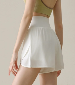 Detail view of white high-waisted shorts with double-layer design and side split detail