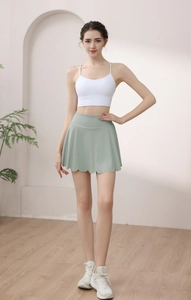 Full view of mint green high-waisted yoga skirt with unique scalloped petal hem and white top