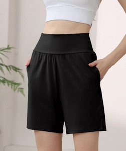 Detail of high waisted black nylon sports shorts with side pockets and hem slits