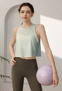 Détail du débardeur de sport en mesh respirant vert clair et du legging de yoga olive