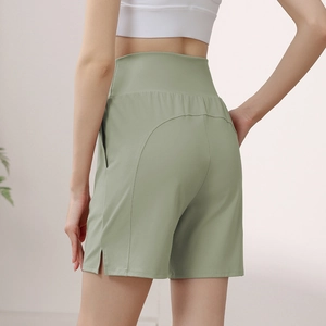 Women's high-waisted loose fitness shorts in light green with side slit detail