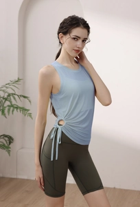 Detail of light blue drawstring yoga tank top and green cycling shorts with side pockets