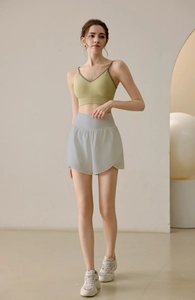 Detail of high-waist loose athletic shorts with side split and curved hem design