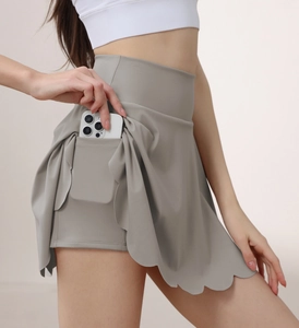 Detail of grey yoga skort featuring a built-in side pocket with a phone storage view