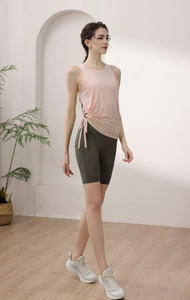Detail view of pink sleeveless yoga top with drawstring ruched waist and olive green shorts