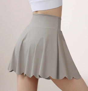 Close-up of high-waisted grey yoga skirt featuring a unique wavy petal hemline design
