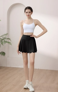 High-waisted black petal yoga skirt with ruffled hem paired with white sports top