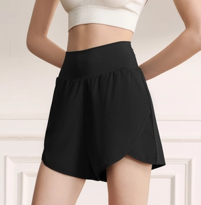 Detail of high-waisted black sports shorts with double-layer design and side slits