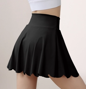 Detail showing the laser-cut scalloped edge and high-waist fit of the black tennis skirt