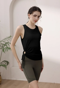 Detail of black drawstring yoga tank top and olive green high-waisted fitness shorts