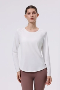 Close-up of white long-sleeved yoga top with seamless stitching and curved hemline