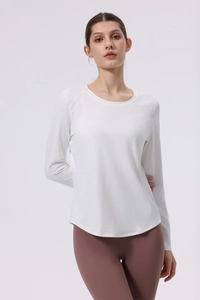 Detailed view of white slim-fit yoga top with seamless stitching and curved hemline