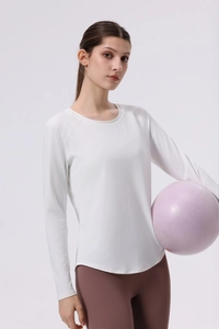 Detailed view of white long sleeve yoga top with curved hem and quick-dry fabric