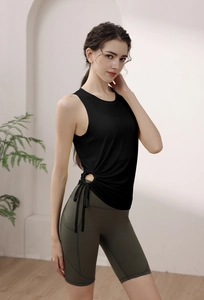 Detail of drawstring cut-out on black yoga vest with olive green high waist shorts