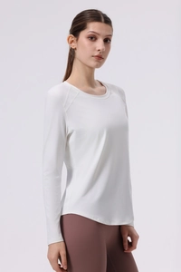 Close-up of white yoga top showing ergonomic flatlock seams and curved hem detail