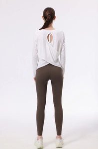 Vista posteriore dettagliata del top da yoga bianco con apertura a goccia e design a strati