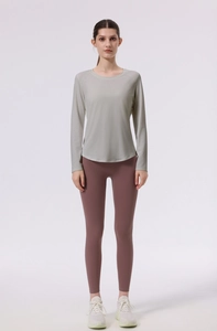 Close-up of seamless light grey long sleeve yoga top with curved hem and slim fit design