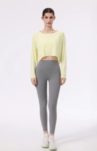 Detail der gelben gerippten Yoga-Oberteil und grauen Leggings für Fitness-Training